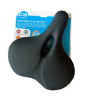A black C9 Cross Support XL air flow balance bicycle saddle resting on its original blue and white retail packaging, placed on a gray wood floor.