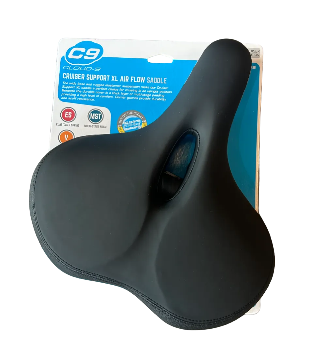 A black C9 Cross Support XL air flow balance bicycle saddle resting on its original blue and white retail packaging, placed on a gray wood floor.