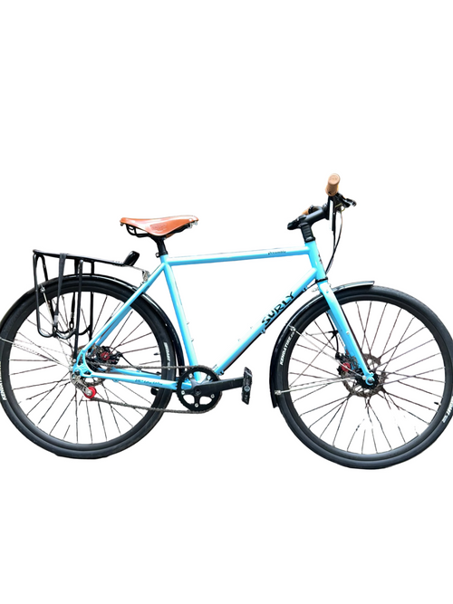 Blue bicycle parked on a sidewalk in front of a store window.