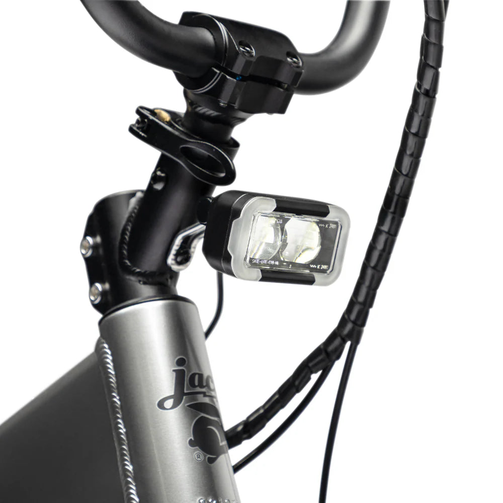 Close-up of a bicycle handlebar with a light attached, featuring the brand 'Jade'.