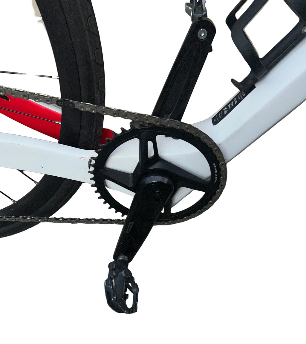 Close-up of a bicycle chain and gear system on a tiled pavement.