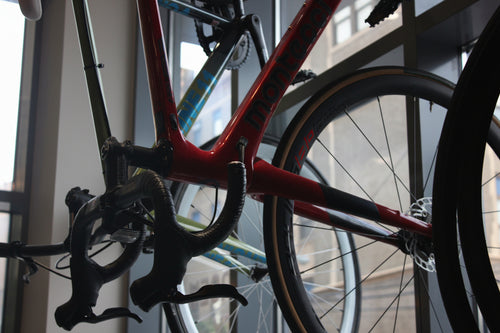 Red bicycle with 'more' branding on a blurred indoor background