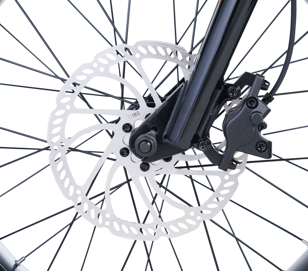 Close-up of a bicycle disc brake system with white rotor and black caliper.