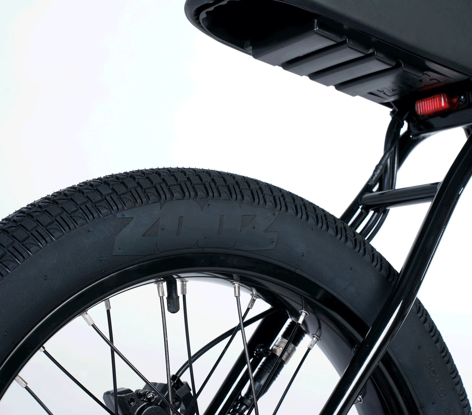 Close-up of a bicycle wheel with a tire and chain, on a light gray background