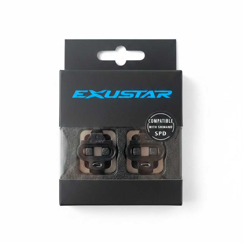 A pair of black Exustar SPD compatible quick release bottle caps in their original retail packaging, displayed on a light wood background.